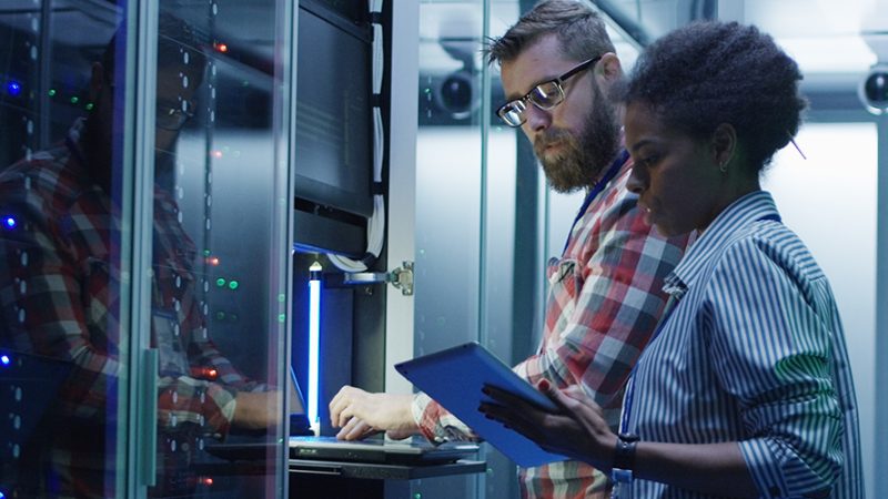 Dos especialistas de TI analizando la operación de un centro de datos